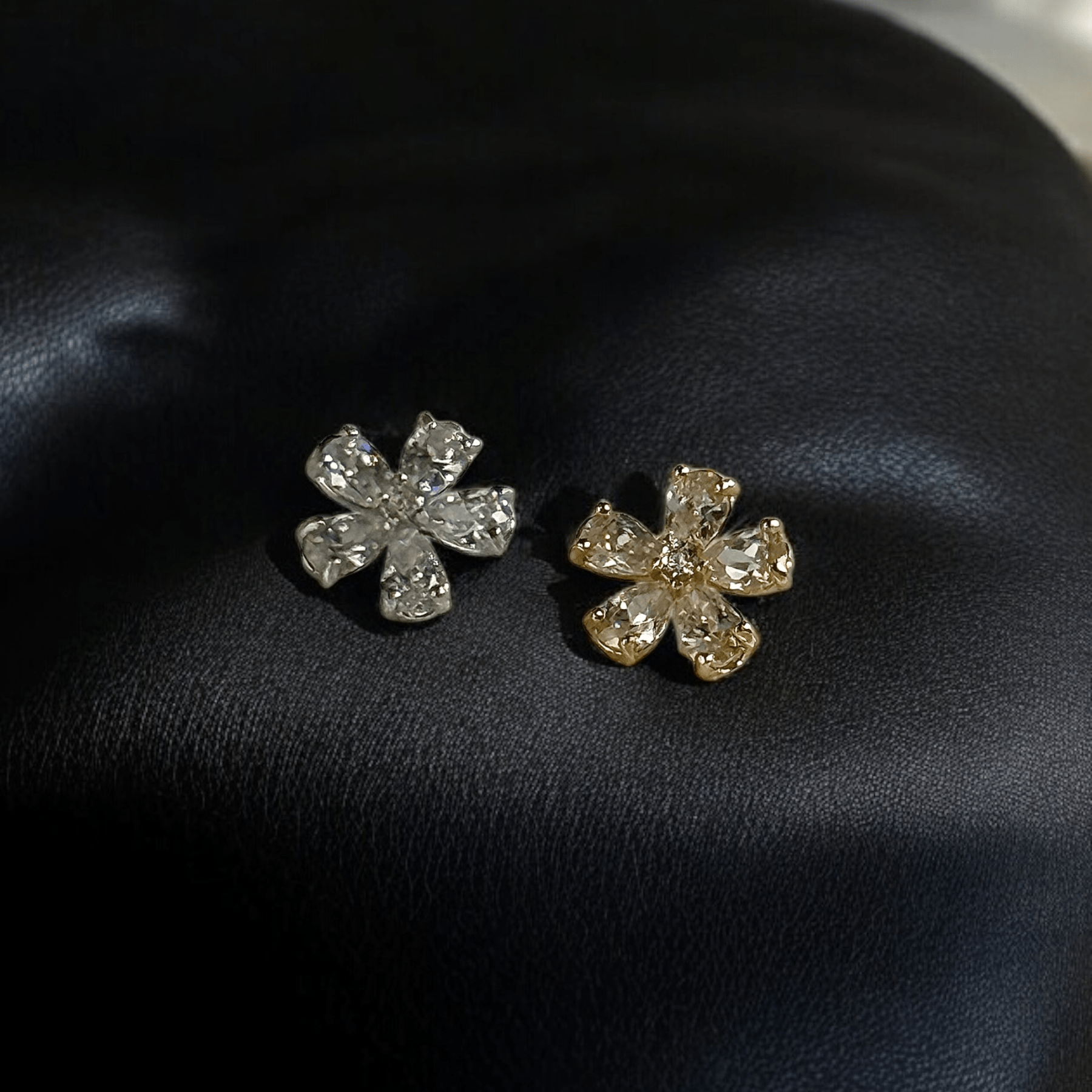 a pair of earrings sitting on top of a black cushion