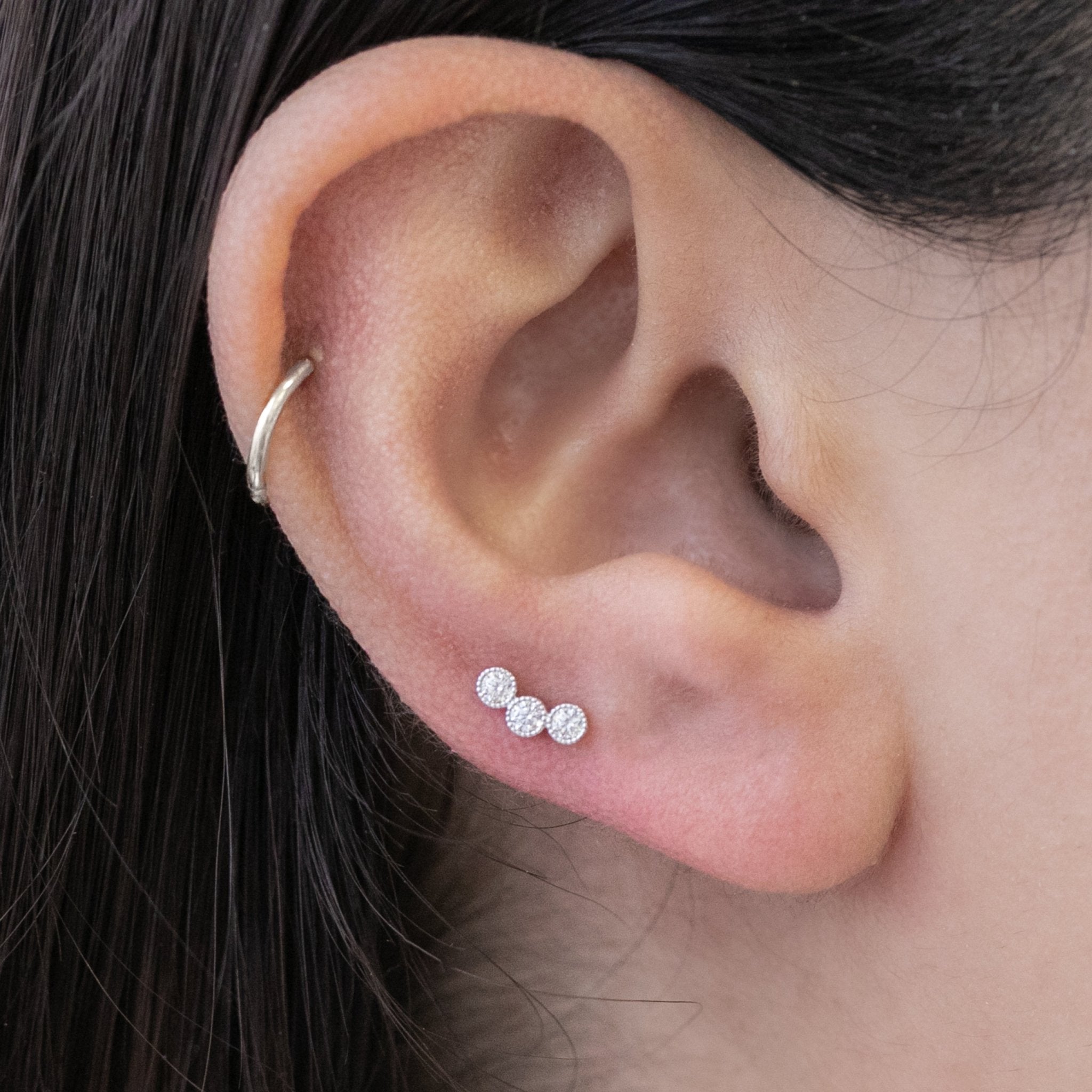 a close up of a person wearing a pair of ear piercings